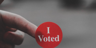 Photo of a red circular badge saying I voted.